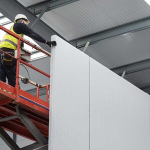 Cold Room constuction worker installing panels on a scissor lift